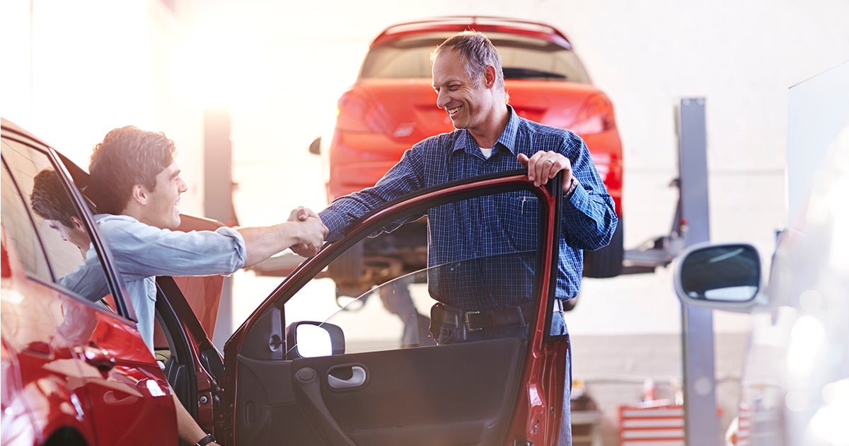A customer shaking hands with his mechanic.